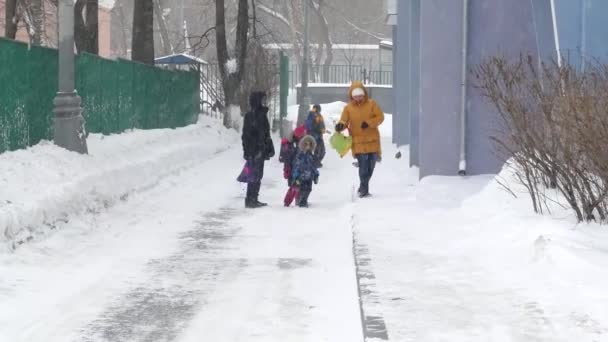 Los escolares después de las clases de invierno, nieve — Vídeos de Stock