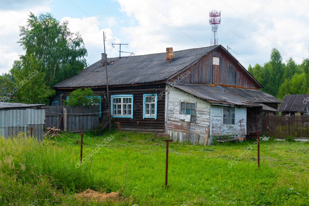 old house and fence in the village in summer
