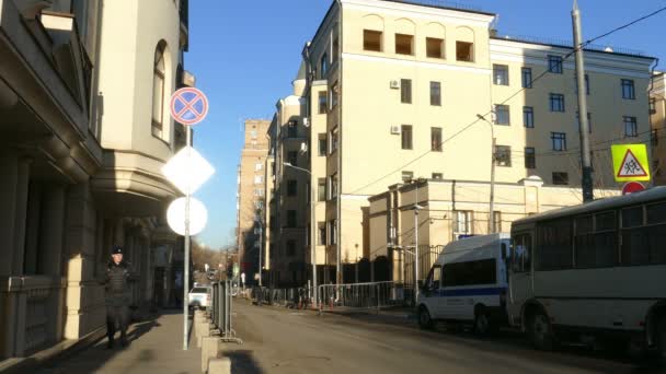 Az emberek sétálnak a város utca: A török nagykövetség keskeny Street régi épület rendőr biztonsági őr a Black egységes van séta a ház — Stock videók