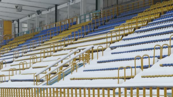 Κίτρινο μπλε καρέκλες που καλύπτονται με χιόνι, στάδιο — Αρχείο Βίντεο