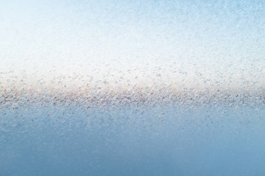 Snow patterns on the glass. Frost texture from the ice crystals on the glass of the window, strong cold concept. Copy space for your design or text. 