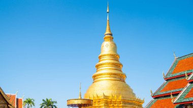 Berrak Mavi Gök 'ün altındaki görkemli Altın Pagoda Yeşiller, Geleneksel Tayland Budist Mimarisi