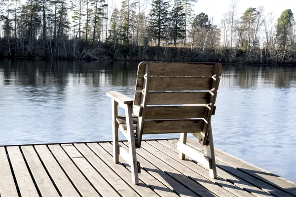 Деревянный стул у реки — стоковое фото