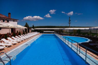 Sakin ol ve Sv club hotel Village açık mavi su havuzu tarafından güneşlenin. Yüzme Havuzu Köyü.