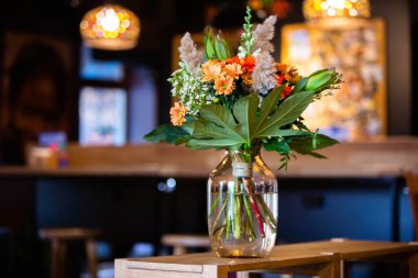 Modern ofiste vazo dolusu çiçekli çalışma masası. Modern bir odadaki bir masanın üzerinde bir buket çiçek..