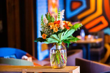 Modern ofiste vazo dolusu çiçekli çalışma masası. Modern bir odadaki bir masanın üzerinde bir buket çiçek..