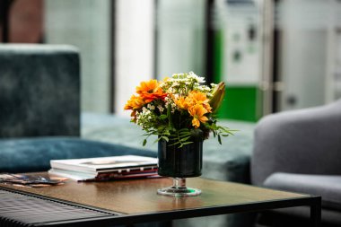 Modern ofiste vazo dolusu çiçekli çalışma masası. Modern bir odadaki bir masanın üzerinde bir buket çiçek..