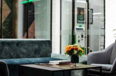 Modern ofiste vazo dolusu çiçekli çalışma masası. Modern bir odadaki bir masanın üzerinde bir buket çiçek..