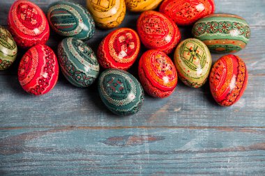 Ahşap arka planda renkli Paskalya yumurtaları. Mutlu Paskalyalar. Metin için boşluk.