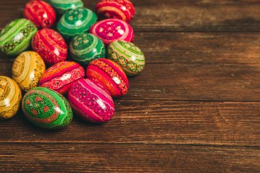 Ahşap arka planda renkli Paskalya yumurtaları. Mutlu Paskalyalar. Metin için boşluk.