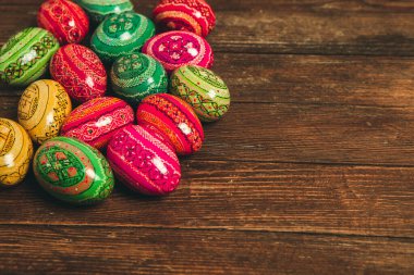 Ahşap arka planda renkli Paskalya yumurtaları. Mutlu Paskalyalar. Metin için boşluk.