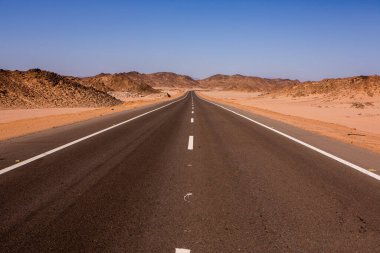 Mısır 'ın Sahara Çölü' nde yol. Özgürlük kavramı, yolculuğun tadını çıkarmak. Boş yol. Otoyol, Çölün ortasındaki otoban