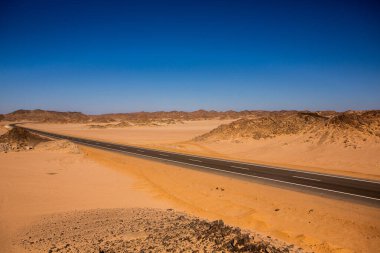 Mısır 'ın Sahara Çölü' nde yol. Özgürlük kavramı, yolculuğun tadını çıkarmak. Boş yol. Otoyol, Çölün ortasındaki otoban