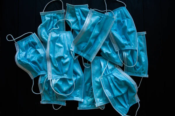 Used blue surgical protective masks. Pollution by surgical masks during the coronavirus pandemic. Covid-19 plastic waste and garbage, disposable masks.