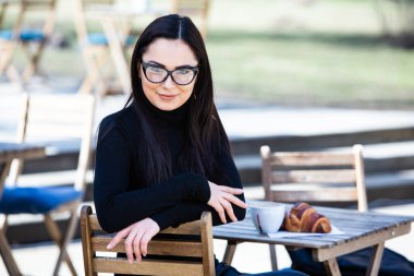 Siyah deri kıyafetler ve gözlük takmış güzel bir Rus kızı. Kentsel arka planda rock tarzı Avrupalı kadın.