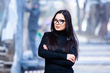 Siyah deri kıyafetler ve gözlük takmış güzel bir Rus kızı. Kentsel arka planda rock tarzı Avrupalı kadın.