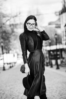 Siyah deri kıyafetler ve gözlük takmış güzel bir Rus kızı. Kentsel arka planda rock tarzı Avrupalı kadın.