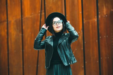 Siyah deri kıyafetler ve gözlük takmış güzel bir Rus kızı. Kentsel arka planda rock tarzı Avrupalı kadın.