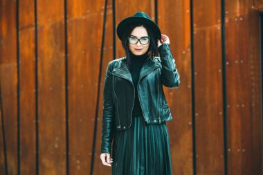 Siyah deri kıyafetler ve gözlük takmış güzel bir Rus kızı. Kentsel arka planda rock tarzı Avrupalı kadın.