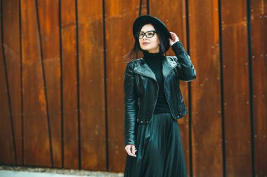 Siyah deri kıyafetler ve gözlük takmış güzel bir Rus kızı. Kentsel arka planda rock tarzı Avrupalı kadın.