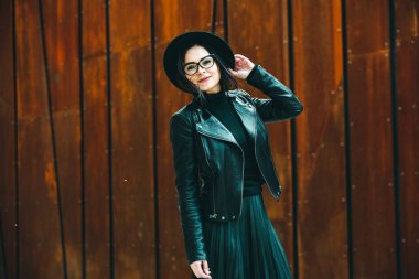 Siyah deri kıyafetler ve gözlük takmış güzel bir Rus kızı. Kentsel arka planda rock tarzı Avrupalı kadın.