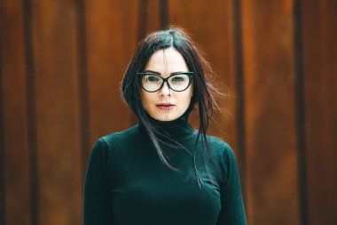 Güzel seksi manken kadın portresi, gözlük takıyor. Gözlüklü, siyah elbiseli, şık bir kadın kameraya bakıyor.