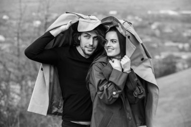 Genç ve şık bir çiftin güzel şehvetli portresi. Parkta yağmurluk giymiş güzel esmer bir çiftin resmi. Mutlu aile