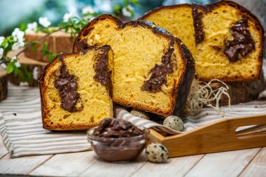 Ev yapımı Panettone. Geleneksel İtalyan tatlı ekmeği. Ahşap bir masada servis edilen bir dilimle Panettone.