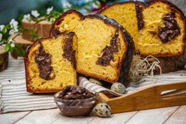 Ev yapımı Panettone. Geleneksel İtalyan tatlı ekmeği. Ahşap bir masada servis edilen bir dilimle Panettone.
