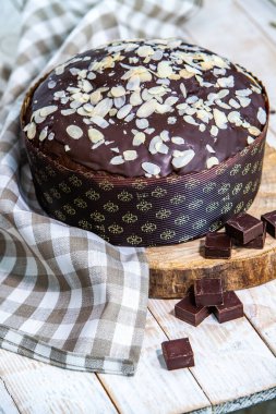 Ev yapımı Panettone. Geleneksel İtalyan tatlı ekmeği. Ahşap bir masada servis edilen bir dilimle Panettone.