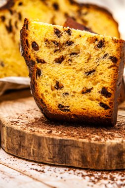 Ev yapımı Panettone. Geleneksel İtalyan tatlı ekmeği. Ahşap bir masada servis edilen bir dilimle Panettone.