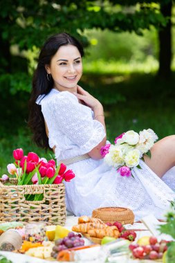 Güzel esmer kadın parkta piknik battaniyesinde dinleniyor. Doğada dinlenmek..