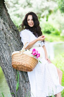 Güzel esmer kadın parkta piknik battaniyesinde dinleniyor. Doğada dinlenmek..