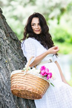 Güzel esmer kadın parkta piknik battaniyesinde dinleniyor. Doğada dinlenmek..