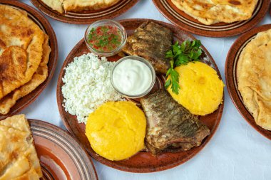 Ev yapımı Romen yemekleri ızgara balık, polenta, turta, kırmızı şaraplı sebze. Kamp tabağı.