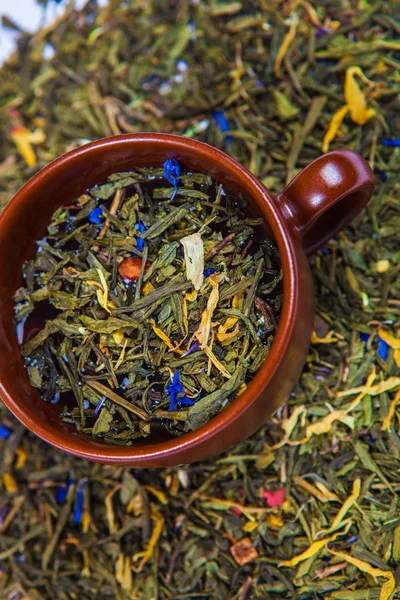Niveles de té verde seco en la taza marrón — Foto de Stock