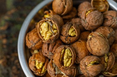 Ceviz kabuğu soyulmuş çekirdekler ve ahşap arka planda cevizler. Sağlıklı fındık yemeği. Makro. Kırık kabuklar.