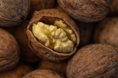 Ceviz kabuğu soyulmuş çekirdekler ve ahşap arka planda cevizler. Sağlıklı fındık yemeği. Makro. Kırık kabuklar.