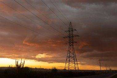 Gün batımında elektrik direkleri. Elektrik dağıtım istasyonu. Enerji endüstrisi.
