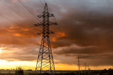 Gün batımında elektrik direkleri. Elektrik dağıtım istasyonu. Enerji endüstrisi.