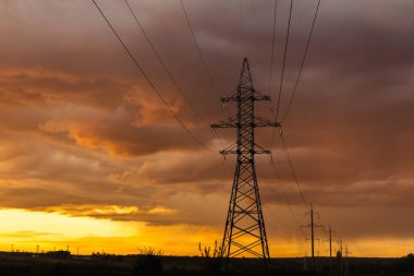 Gün batımında elektrik direkleri. Elektrik dağıtım istasyonu. Enerji endüstrisi.