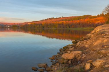 Moldova Cumhuriyeti 'ndeki huzurlu sonbahar manzarası. Renkli ormanlar, altın ağaçlar ve yumuşak güneş ışığı.