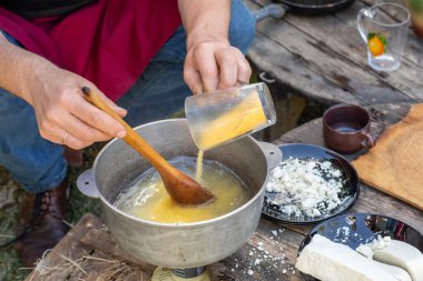 Kırsal Polenta 'yı Koyun Peyniri ile Açık Ateş' e Hazırlayan Adam. Otantik Taşra Yemekleri. Kırsal Doğa Yemekleri. Geleneksel köy mutfağı. Kalıtsal Gıda Sahnesi