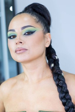 Beautiful European woman getting artistic makeup applied by a professional makeup artist in a modern beauty salon, beauty, glamour and elegance concept.