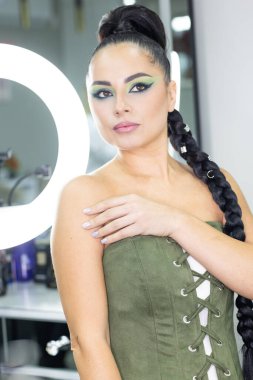 Modern bir güzellik salonu, güzellik, cazibe ve zarafet konseptinde profesyonel bir makyöz tarafından sanatsal makyaj yaptıran güzel Avrupalı bir kadın..