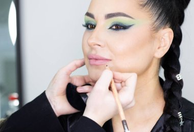 Bir güzellik salonunda profesyonel makyaj ve kuaförlük yaparken önemli bir role hazırlanan zarif bir aktris.