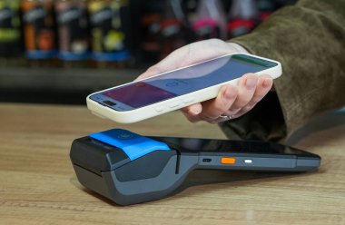 Dükkanda kredi kartı okuyucu kullanan birinin yakın çekimi.