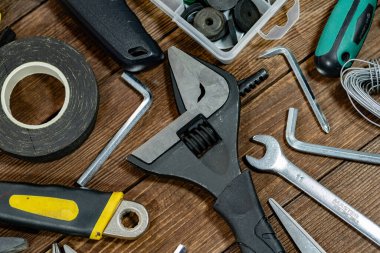 Profesyonel bina ve ev bakımı araçları kırsal ahşap arka planda sergileniyor. Ev geliştirme, tadilat, işçilik, atölye organizasyonu ve inşaat endüstrisi temel gereksinimleri.