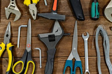 Profesyonel bina ve ev bakımı araçları kırsal ahşap arka planda sergileniyor. Ev geliştirme, tadilat, işçilik, atölye organizasyonu ve inşaat endüstrisi temel gereksinimleri.