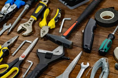 Profesyonel bina ve ev bakımı araçları kırsal ahşap arka planda sergileniyor. Ev geliştirme, tadilat, işçilik, atölye organizasyonu ve inşaat endüstrisi temel gereksinimleri.